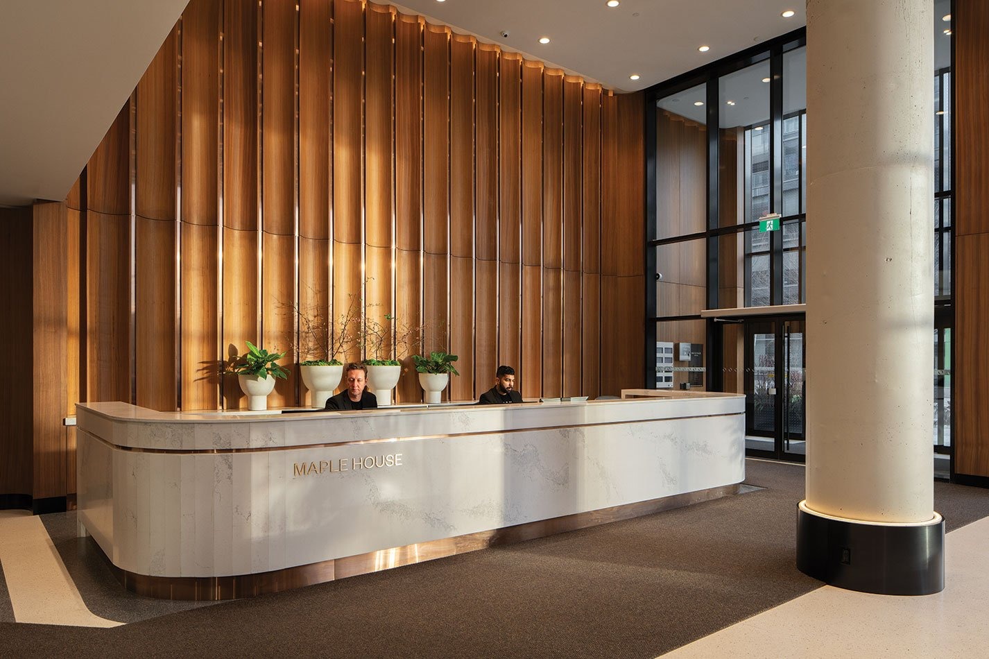 Reception desk in a modern condominium lobby with wood-panelled walls